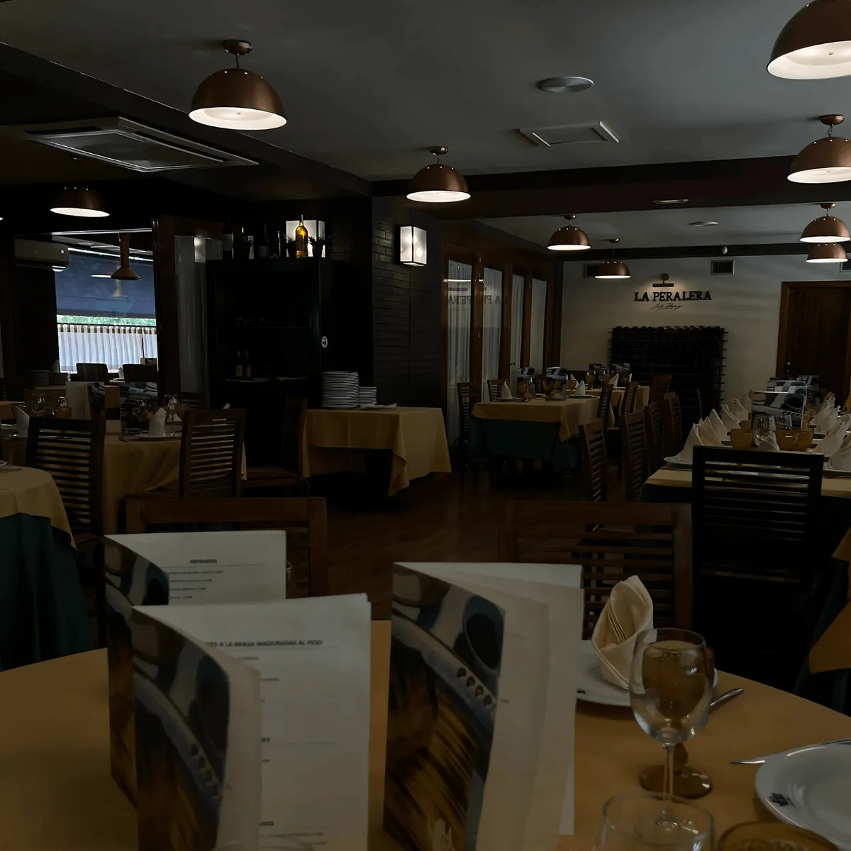 Salón interior de La Peralera con mesas vestidas